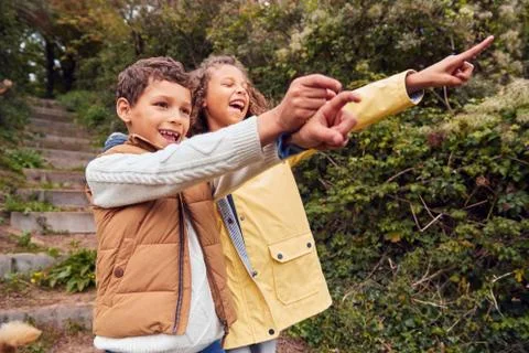 Two Children Walking Down Steps And Pointing In Countryside On Winter Beach Stock Photos