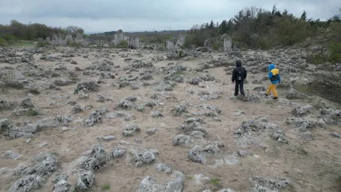 Two children walking through rocky landscape and limestone formations. Outdoor Stock Footage 324879674