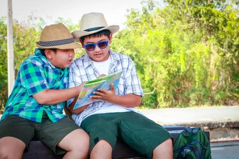 Two children watching the map Sit and wait for the train 库存照片