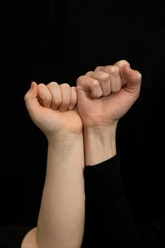 Two children's hands are facing each other and clenched into fists. Stock Photos