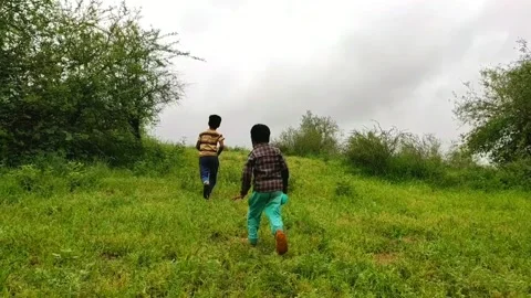 Two childrens running on grass land (slow motion) Stock Footage 136925964