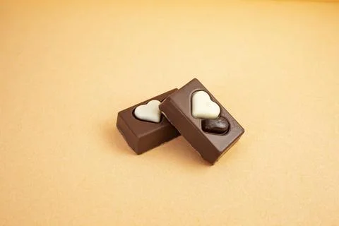 Two chocolate candy rectangles with hearts on cream background  and copy sp.. Stock Photos