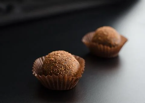 Two chocolate sweets over black Stock Photos