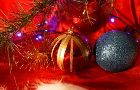 Two christmas balls on red background with fir branch. Stock Photos