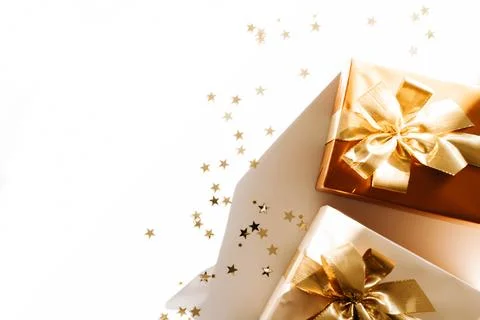 Two Christmas gift boxes, adorned with vibrant golden ribbons on white back.. Stock Photos