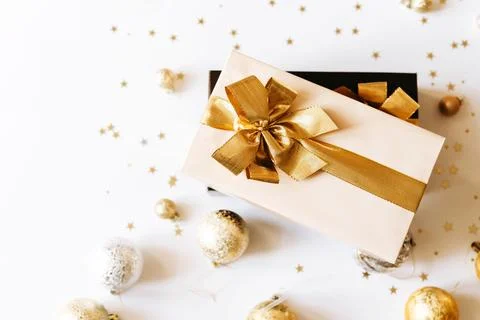 Two Christmas gift boxes, adorned with vibrant golden ribbons on white backgr Stock Photos