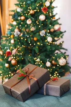 Two Christmas gift boxes decorated with ribbon and red holly berry in front.. Stock Photos