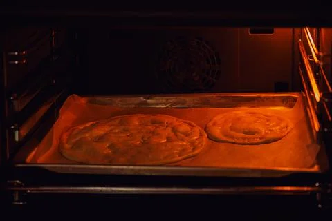 Two circles of fried dough on parchment paper baked in the oven, diet pancake 库存照片