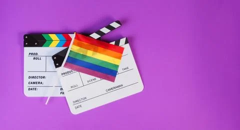 Two Clapper board and rainbow pride flag on purple or violet background. Stock Photos