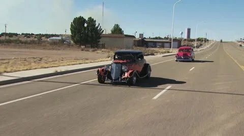 Two Classic Cars Driving Down the Road Video stock 19129178
