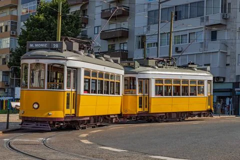 Two classic yellow trams, both on the Tram 28 route. Lisbon Portugal. Stock Photos
