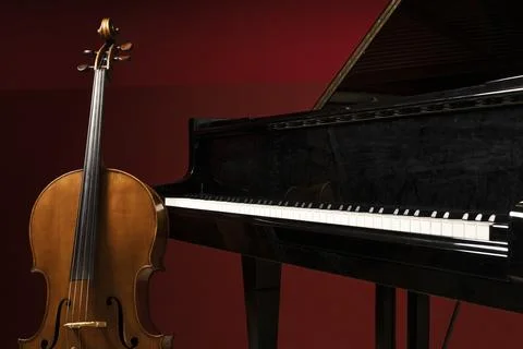 Two classical instruments - the cello and the grand piano - on a stage waitin Stock Photos