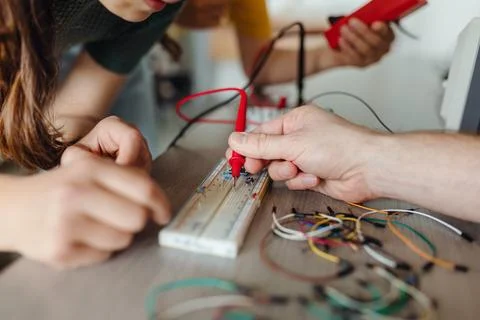 Two classmates working together on circuit board, building robot in after-school Fotos de archivo