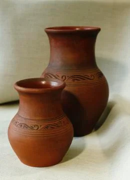 Two clay pots on the background of linen cloth with pleats close up Stock Photos