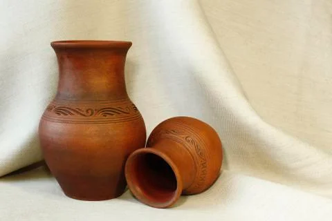 Two clay pots on the background of linen cloth with pleats close up Stock Photos