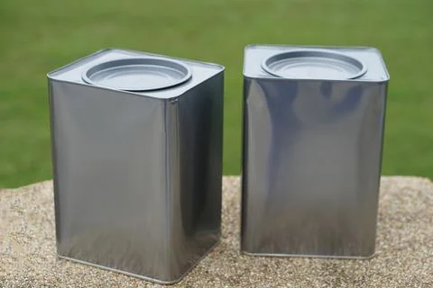 Two clean rectangular metal tin cans with sealed lids displayed outdoors on a st Fotos de archivo