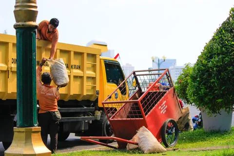 Two cleaners are loading garbage into a truck in the Monas area Stock Photos