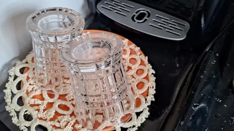 Two clear crystal glasses resting upside down on orange plate Stock Photos