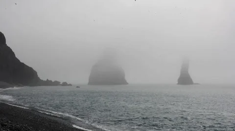 Two cliffs in the sea partially covered by the sick fog, Iceland Stock Footage 33768828