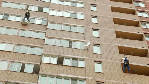 Two climber spends repair work on a multi-storey building height Vídeo Stock 136615373