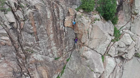 Two climbers are making their way up a steep rock face Stock Footage 289659480