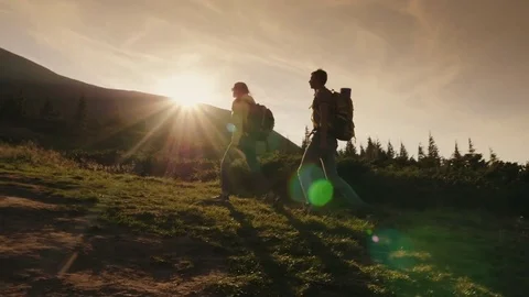 Two climbers climb up the mountain in the sun, side view. Concept - wins and Stock Footage 79707497