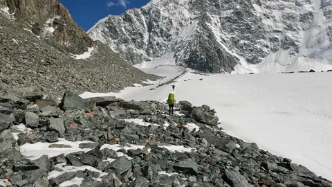 Two climbers with large backpacks are walking on a snowy slope 動画素材 246292243