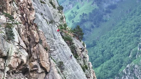 Two climbers make their way up a steep mountain face Stock Footage 289674781