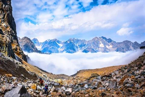 Two climbers move above the clouds Stock Photos
