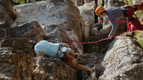 Two Climbers Navigating Rocky Terrain with Safety Gear and Red Ropes on a Sunny Stock Footage 275855663