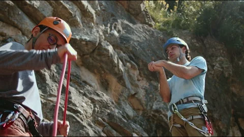 Two Climbers Preparing Gear for Rock Climb, Focused and Ready in Natural Setting Stock Footage 272625414