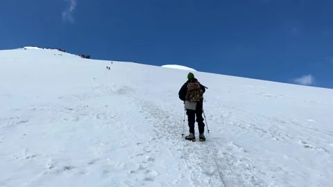 Two climbers walk in a bundle up Mount Elbrus Stock Footage 135515753