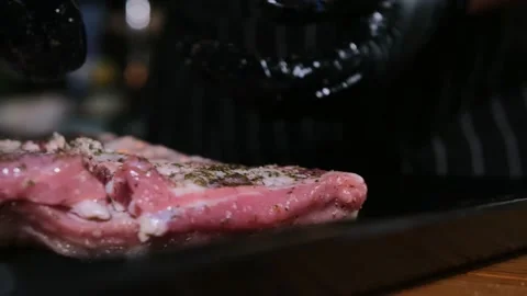 Two clips combined. Raw spiced pork ribs, slowly descending to the tray. Video stock 167706707
