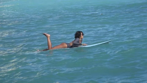 Two Clips Of Pretty Female Surfer Paddling Out, Waikiki Beach, Honolulu, Hawaii Stock Footage 154344309