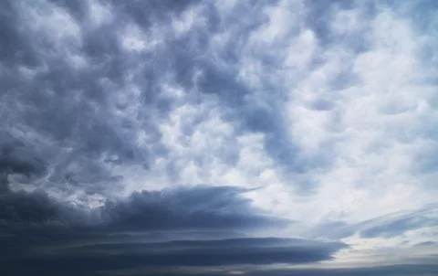 Two cloud formations.  Asperitas clouds and Lenticular clouds. Stock Photos