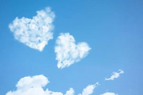 Two clouds in heart shape soar in blue sky. Concept of love, romance and happ 스톡 사진