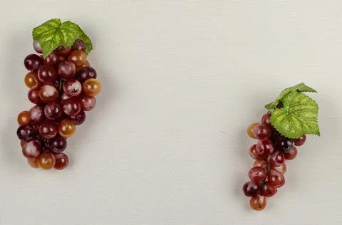 Two clusters of red grapes on a light brown background Stock Photos