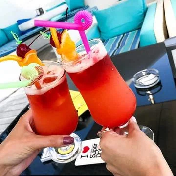 Two cocktail in the hands on the beach Stock Photos