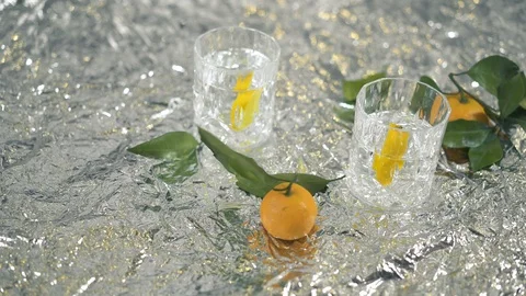 Two cocktails with lemon and mandarins on the table with blinking foil 스톡 동영상 105454953