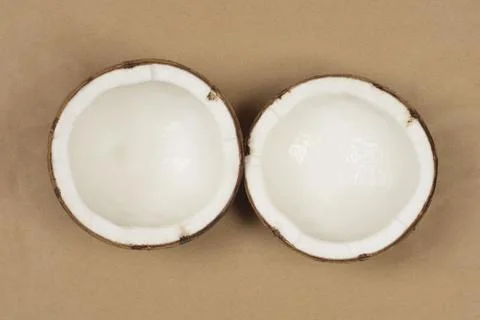 Two coconut halves with fresh white meat on paper background 写真素材
