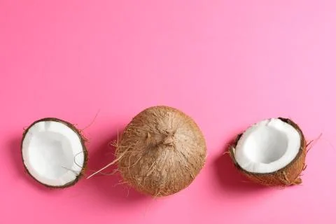 Two coconut one of which split on color background, space for text Stock Photos