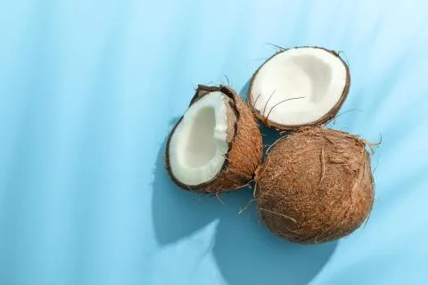 Two coconut one of which split on color background Stock Photos