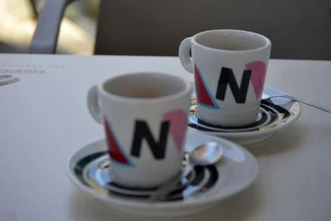 Two coffee cups with brewed coffee, white coffee cups and saucers with motifs Stock Photos