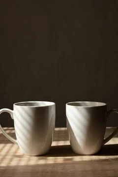 Two Coffee Cups Centered in Bottom Third with Side Lighting Stock Photos