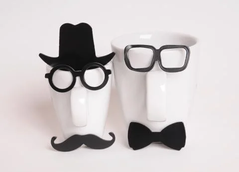 Two coffee cups in mans image. Hipster style, glasses, mustache, hat, bow tie Stock Photos