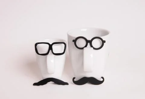 Two coffee cups in mans image. Hipster style, glasses, mustache Stock Photos