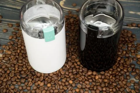 Two coffee grinders with coffee beans isolated on the wooden tables Stock Photos
