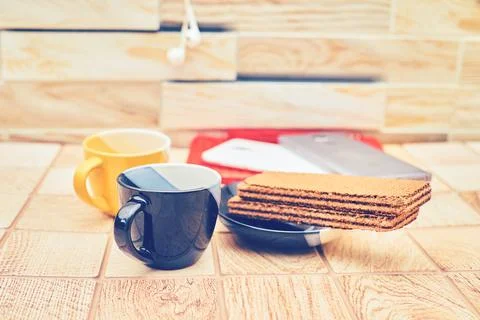 Two coffee tea cups, waffles and smartphones on a wooden table 스톡 사진