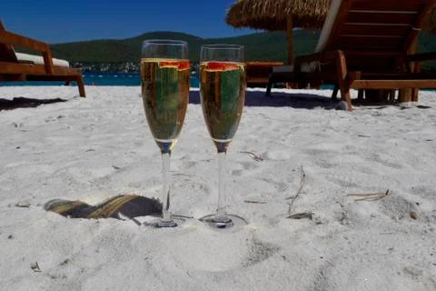 Two cold glasses of champagne with raspberry on white sand on the beach in an Stock-Fotos