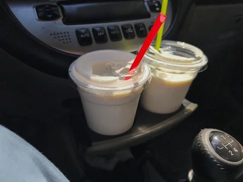 Two cold refreshing milkshakes or smoothies in plastic cups with colorful str Foto stock